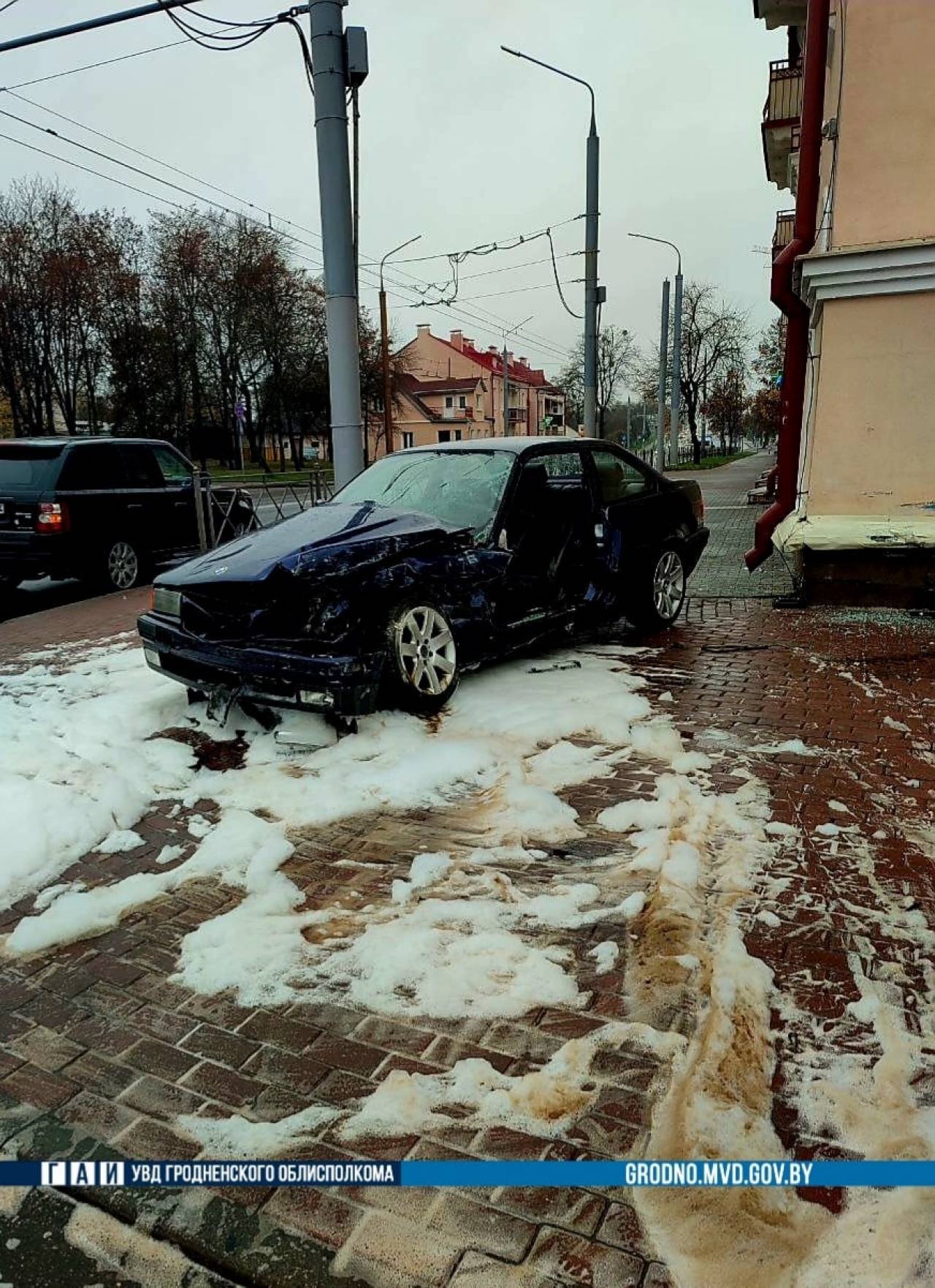 Молодой водитель BMW в заносе улетел в угол дома в Гродно. Его «вырезали» спасатели